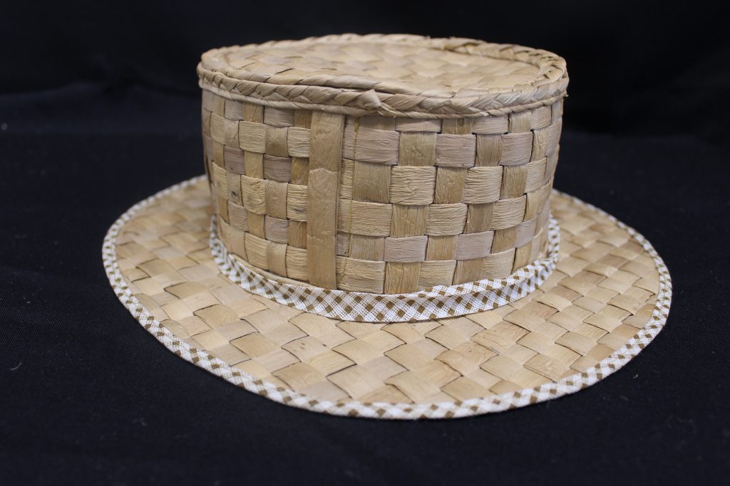 Número do registro 271  Descrição Bolsa de fibra vegetal com forro interno de tecido industrial e alças revestidas de couro curtido ou sintético.  Matéria prima Fibra (talo) de aguapé (Eichhornia crassipes), tecido e couro  Povo Indígena Guató  Técnica Trançado de fibras vegetais (talos secos e desidratados de aguapé) com costuras interna (de tecido) e externa (de couro)